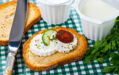 Apetizing canape with young white cheese, cucumber and tomato