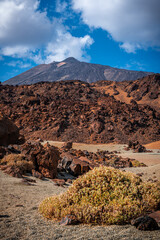 Hiking through the rugged volcanic rock Landscape on Tenerife with Mount Teide in the distance