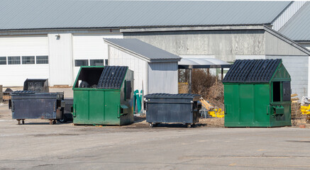 commercial dumpster for trash and recycling outside warehouse