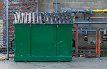 large green commercial dumpster for trash and recycling