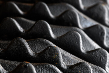Industrial pattern, closeup of black metallic harrow disks with teeth for soil grinding