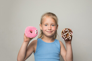 Pretty child girl holding testy donut. Cute little girl with sweet food indoor