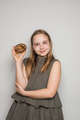 Happy child girl holding testy donut. Cute little girl with sweet food indoor
