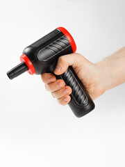 A person is currently holding a black and red dust blower firmly in their hand