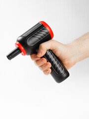 A hand is firmly holding onto a black and red dust blower