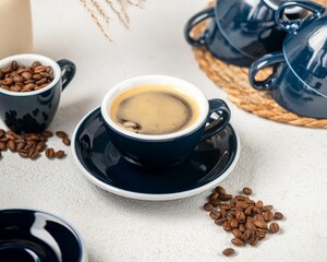 Freshly brewed coffee with beans and blue cups.