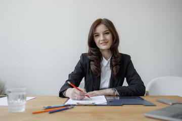 Professional woman engaged in writing notes during a meeting in a modern office setting