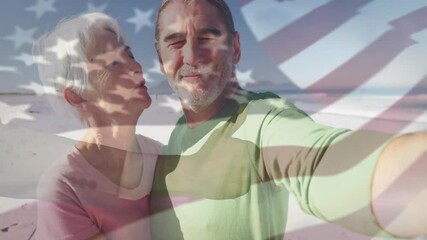 Man holding smartphone taking social media selfie as couple kissing on beach with US flag overlay - Powered by Adobe