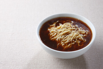 白い丼に具なしのシンプルな醤油ラーメン
