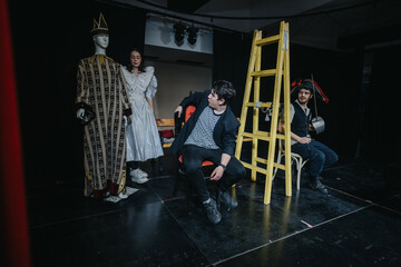Group of young actors showcasing a theatrical play scene with costumes, props, and dramatic...