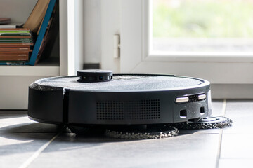 Robot vacuum cleaner with dust, real life photo, saves time and goes into hard-to-reach places
