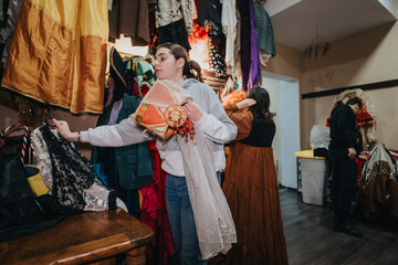 Actors backstage arranging costumes and props, depicting the busy process of preparation for a...