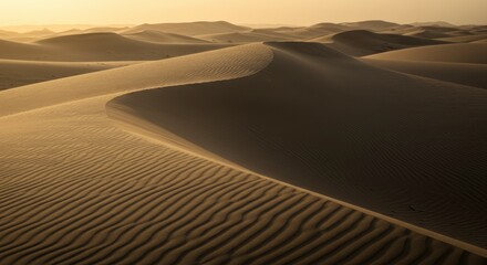 Naklejka premium Golden Hour Desert Landscape Featuring Textured Sand Dunes And Serene Shadows Under Warm Sunlight