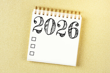 New year resolutions 2026 on desk. 2026 resolutions list with notebook, coffee cup on table. Goals, resolutions, plan, action, checklist concept. New Year 2026 template, copy space