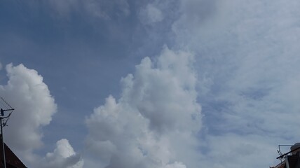  A serene blue sky with fluffy white clouds, showcasing a peaceful and expansive natural view.