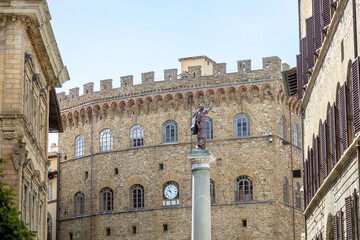 Fototapeta premium The Column of Justice (Colonna della Giustizia) in Piazza Santa Trinita, with Palazzo Spini Feroni and its clock in Florence, Italy