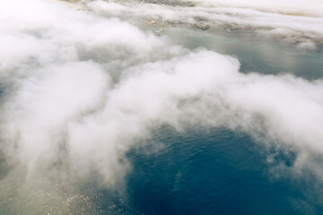 Obraz premium view from helicopter window of white clouds and dark green ocean