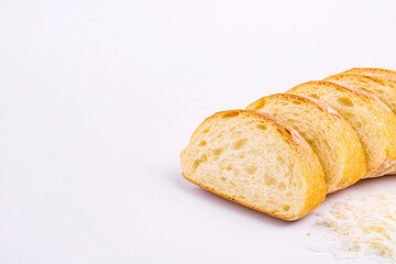 Naklejka premium Sliced baguette displays its crusty, golden exterior and fluffy, porous interior on white background.