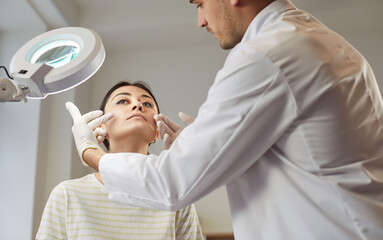 Beauty treatment, cosmetic surgery, beautician, plastic surgeon consulting female patient in...