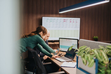 A dynamic team discusses financial reports displayed on screens in a collaborative and professional office environment, emphasizing teamwork, innovation, and productivity in the workplace.