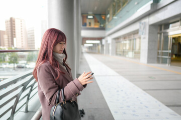 On a cold December morning, a Japanese woman in her twenties with long pink hair and a pink trench...