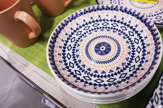 clay plate with blue pattern on blue background. Painted tableware - Powered by Adobe