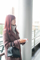 On a cold December morning, a Japanese woman in her twenties with long pink hair and a pink trench...