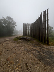 fence sculpture in the middle of a forest with foggy sky on a rainy day on the pilgrimage along the road to Santiago in Portugal