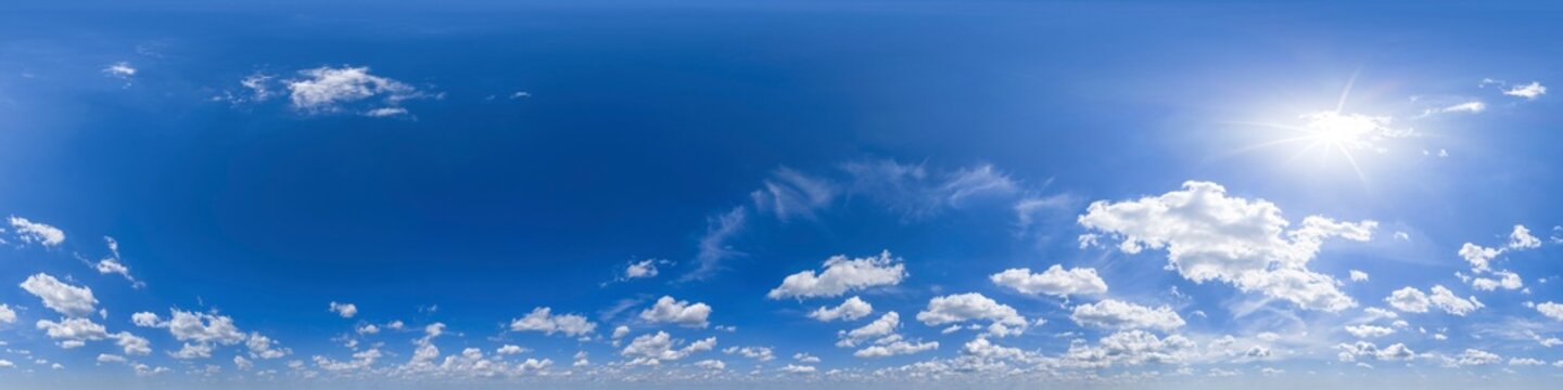 Spherical panorama of blue sky, cumulus clouds and sun shining 