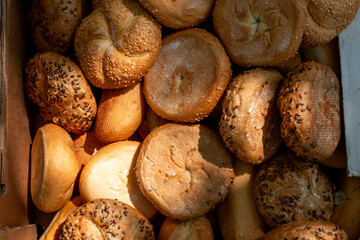 A close-up, top-down view of a variety of freshly baked bread rolls, including plain and seeded options, showcasing their golden-brown crusts and inviting textures