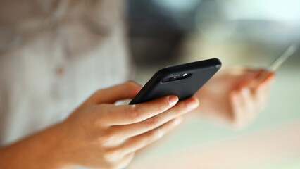 Person, hands or phone with credit card for online shopping, payment or banking app in city. Closeup, shopper or ecommerce with mobile smartphone or debit for remote transaction in urban area