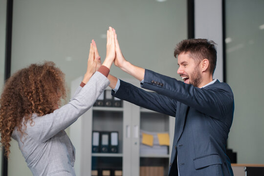 Happy creative business people are motivated, giving high five and celebration successful deal. Cooperation Meeting Partnership Career growth Team building Successful business.