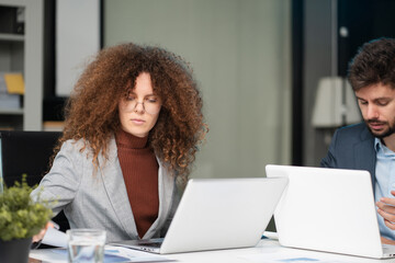 Diverse professionals collaborate on project analysis with financial graphs. Strategic teamwork and...