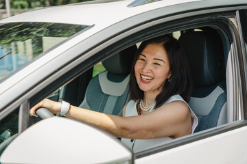 Woman driving an electric car with a smile