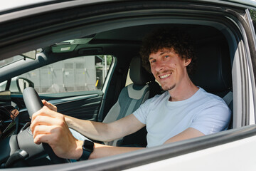 Smiling man driving an eco-friendly electric car