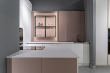 stylish modern built-in kitchen with upper and lower cabinets, drawers, shelves. kitchen facades are white and peach in color. Large, bright kitchen unit. Built-in kitchen appliances. white countertop