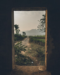 Through the doors of an abandoned house by a lake in Koraput, Odisha, India in November 2024....