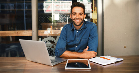 Laptop, portrait and tablet with man in coffee shop to research for small business startup. Computer, remote work and website with happy freelance employee person at cafe or restaurant as customer