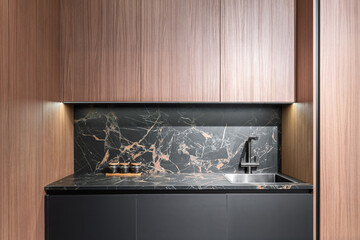 modern built-in kitchen with upper and lower cabinets. wooden and gray kitchen facades, gray marble countertop. built-in kitchen appliances. kitchen backsplash. steel faucet and sink