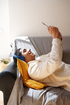 Young man relaxing with technology at home