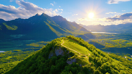 Aerial view of lush green mountain range with winding path, vibrant forest, and dramatic sunlight casting over landscape, evoking sense of tranquility and adventure