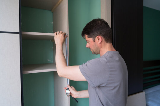 Man building shelves in a closet with precision