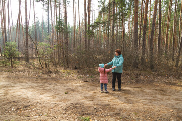grandmother with granddaughter walking and playing in nature in the forest
