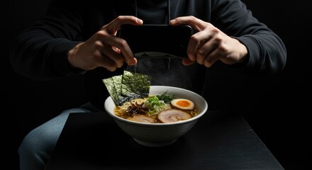 Person Photographing a Bowl of Steaming Ramen with Smartphone