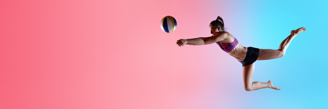 Banner. Side view of female athlete in air reaching arms to hit volleyball with gradient lighting. Powerful save. Copy space. Concept of sport, blocking technique, speed, and coordination .