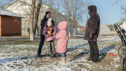 Grandparents with granddaughters playing in the park on a sunny winter day
