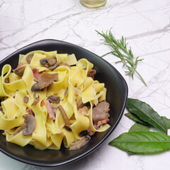 primo piano, piatto con pappardelle ai funghi con pancetta