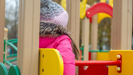 Little girl having fun on playground. Happy healthy little child climbing, swinging and sliding on...