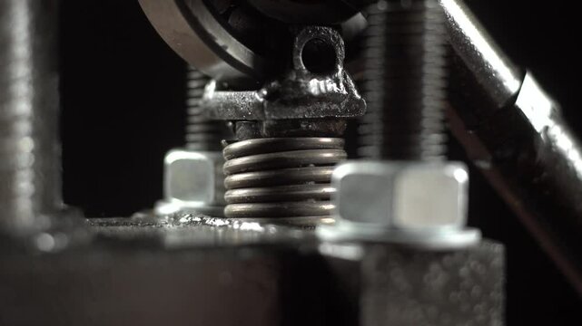 Vertical press spring moves up and down during compression process.