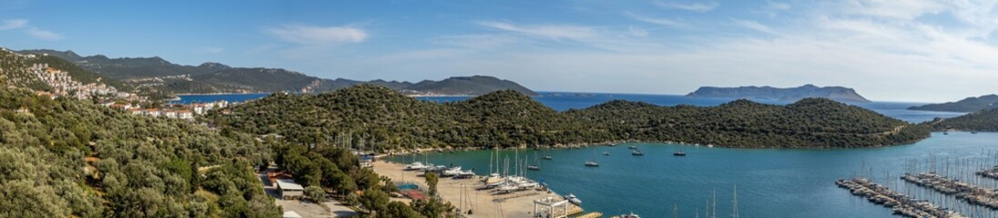 Obraz premium Super wide panorama of Kaş resort with marina, white hillside houses, green peninsula, blue sea and distant islands. Kaş, Turkey, Mediterranean.